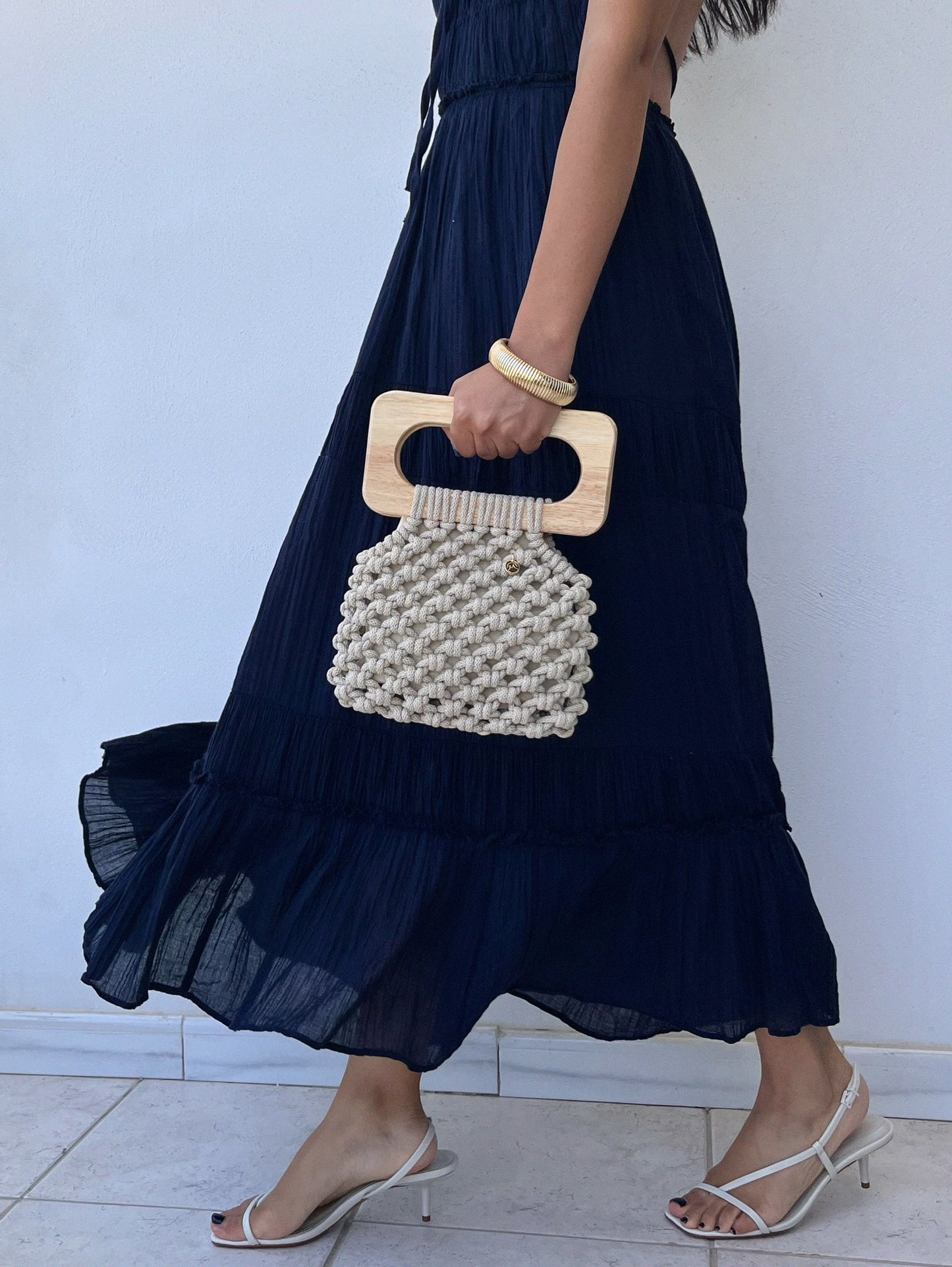 Handmade Koma Bag in Beige styled with a navy blue dress andheeled sandals.