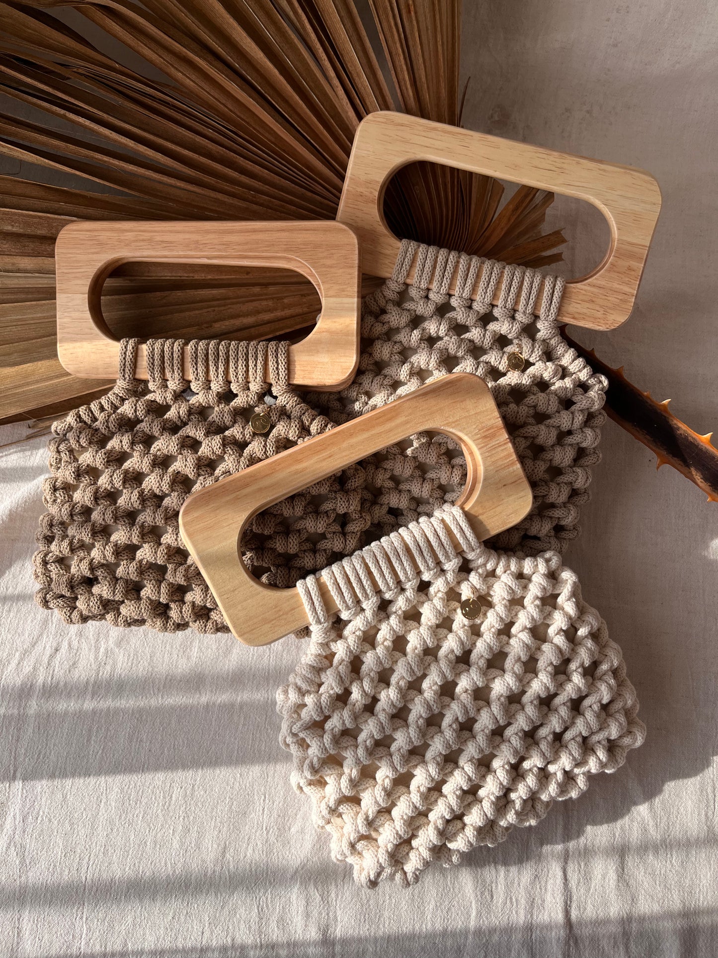 Koma Bags in all colours, beige, natural and sand laying in natural light