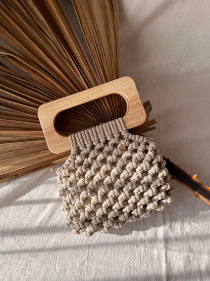 Handmade Koma Bag in Beige laying aesthetically on linen cloth