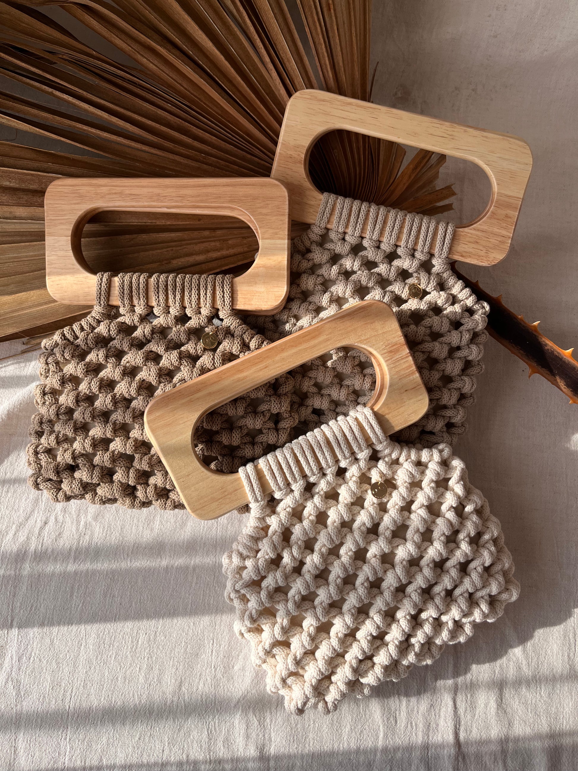 Koma Bags in all colours, beige, natural and sand laying in natural light