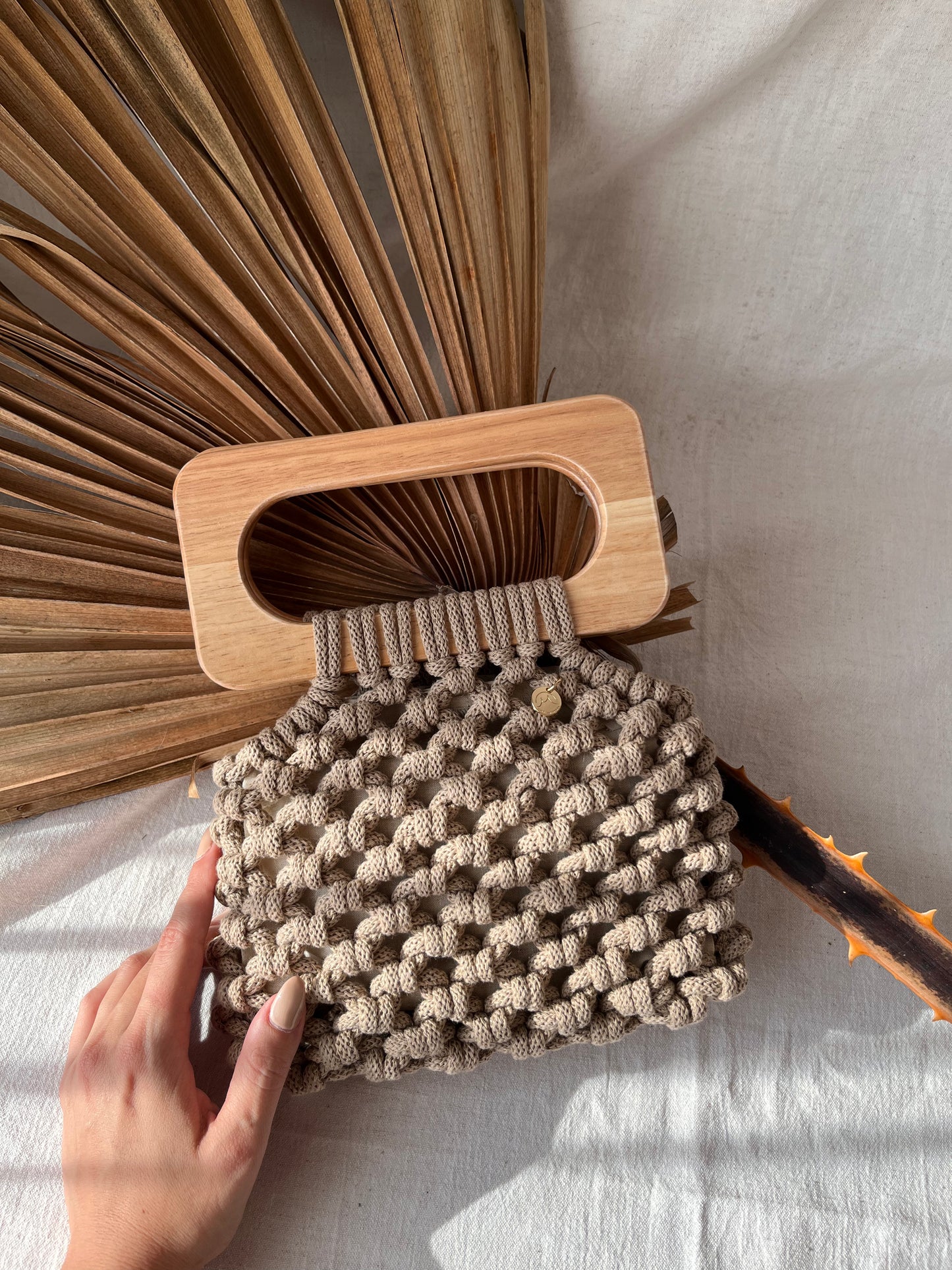 koma bag in sand laying, natural soft light