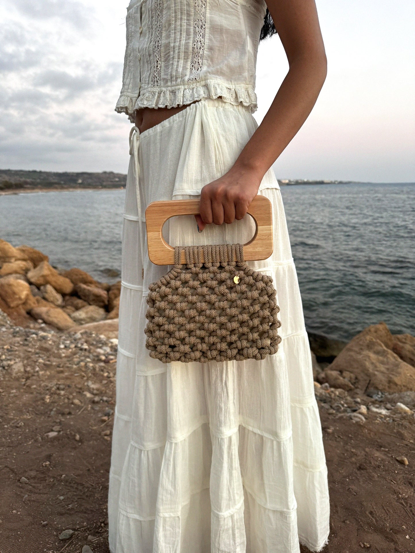 Koma bag in the colour sand, styled with a white two piece summer set, very boho, very summery chic.