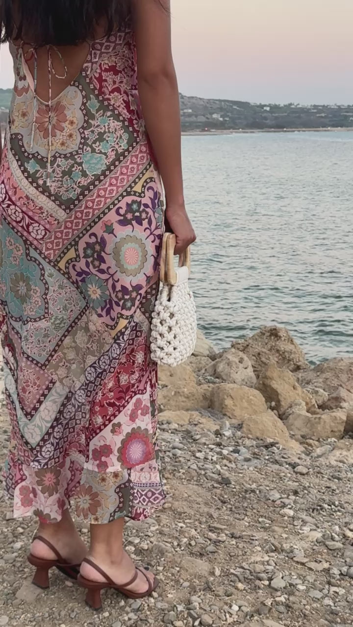Koma Bag in natural styled with a geometric multicoloured flowy dress and brown heeled sandals.