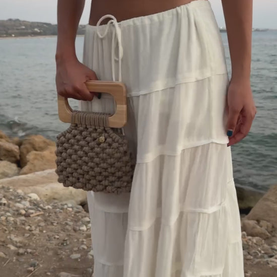 Video of Handmade Koma Bag in Sand styled in a white set, long skirt and crop top.