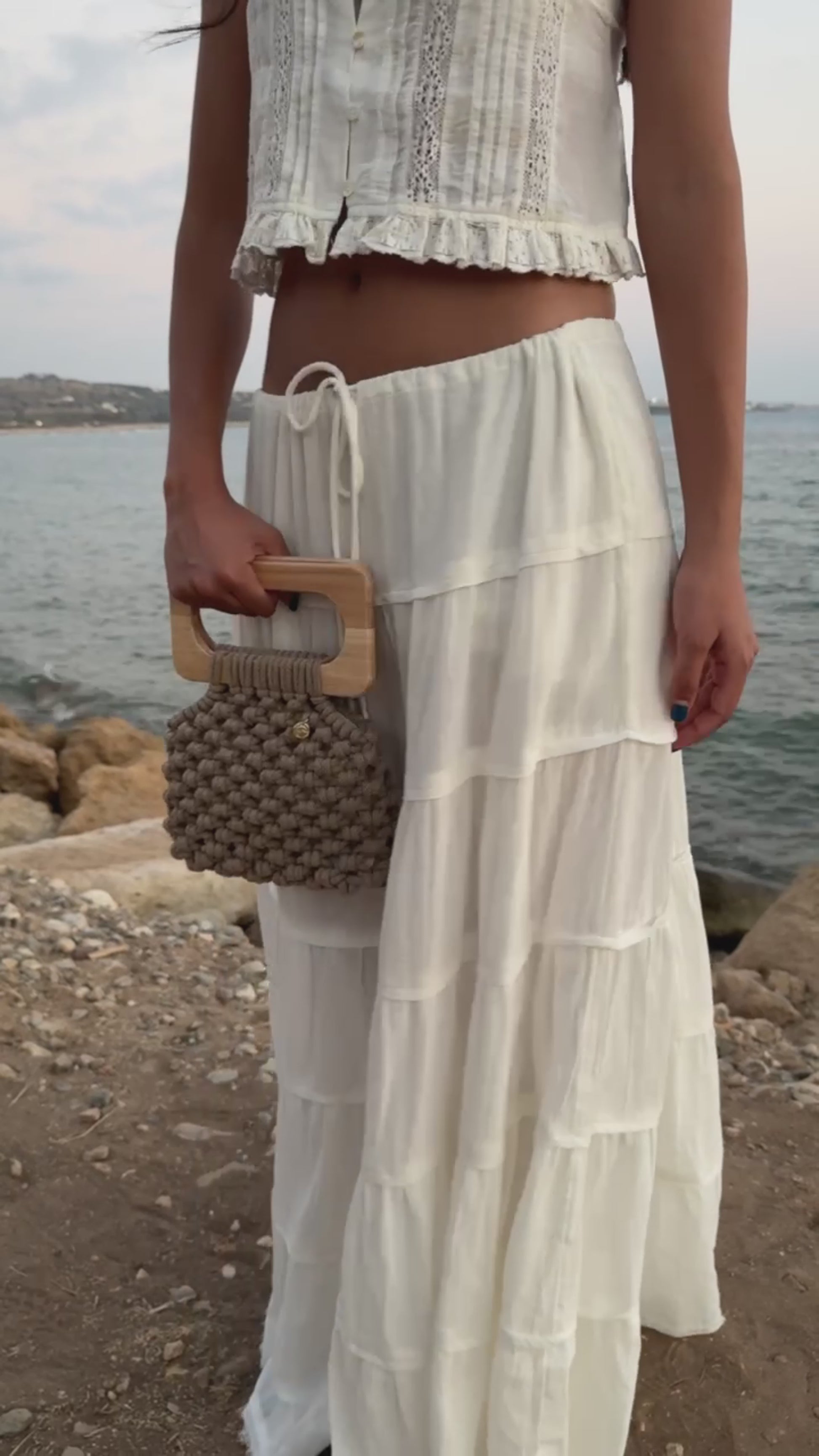 Video of Handmade Koma Bag in Sand styled in a white set, long skirt and crop top.